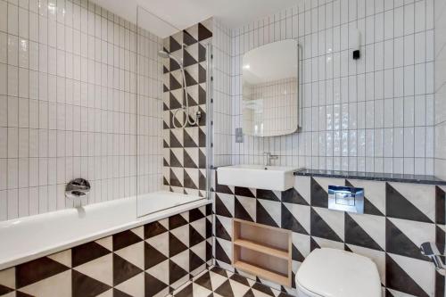 a bathroom with a sink and a tub and a toilet at Wembley Park Modern Flat in London