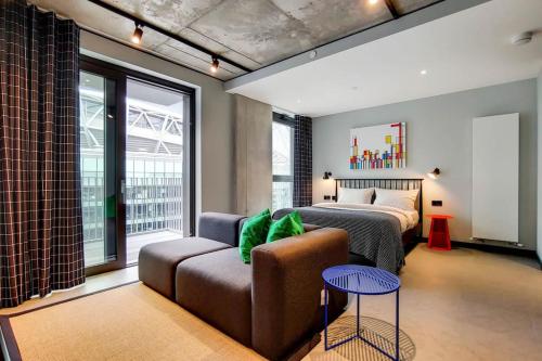 a bedroom with a bed and a couch in a room at Wembley Park Modern Flat in London