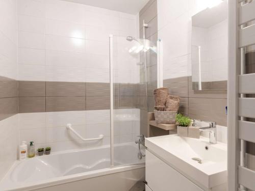 a white bathroom with a tub and a sink at Appartement Saint-Lary-Soulan, 3 pièces, 6 personnes - FR-1-296-384 in Saint-Lary-Soulan