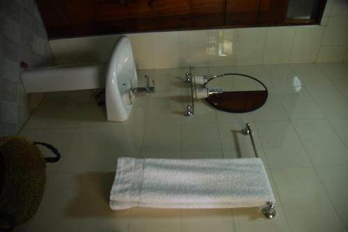 een badkamer met een wastafel, een toilet en een spiegel bij Gamaleo Apartment Namulanda in Namulanda