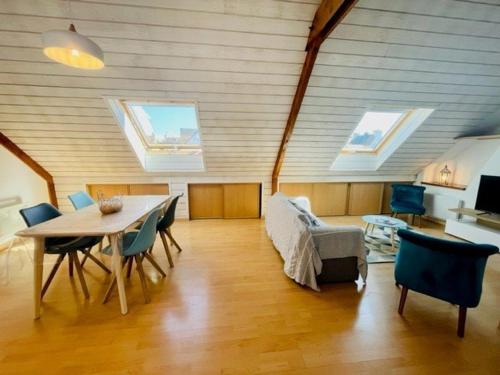 - un salon avec une table, des chaises et des lucarnes dans l'établissement Appartement T3 66m² lumineux, bien équipé, proche centre et plages, stationnement proche - FR-1-478-221, à Quiberon