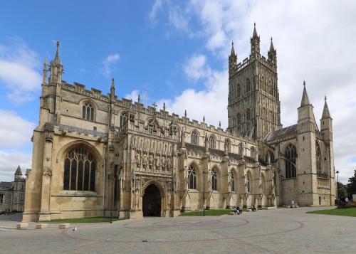 a large stone building with a tower and a cathedral at Luxe Cosy&Spacious 2 Bed House - Super Fast Wi-Fi & Private Parking Near GLO Airport & Cheltenham Racecourse in Churchdown