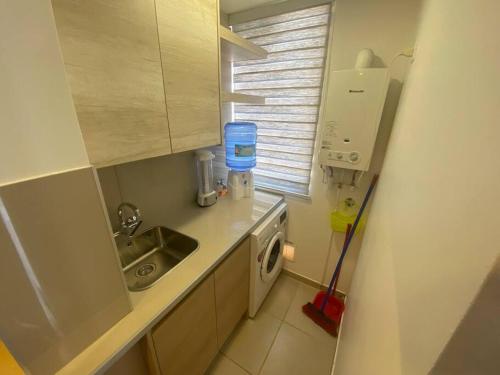 卡尔德拉Cómodo departamento en Caldera, con piscina.的带水槽和洗衣机的小厨房