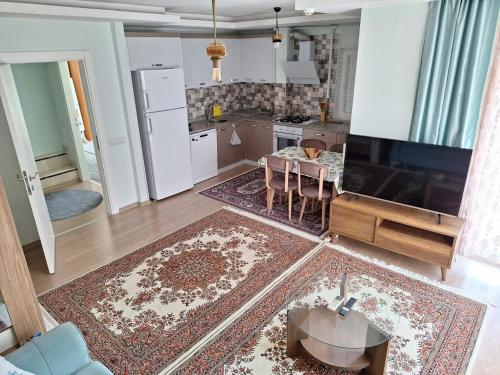 a living room with a table and a kitchen at Family Apart-Hotel 2022 - 6 in Antalya