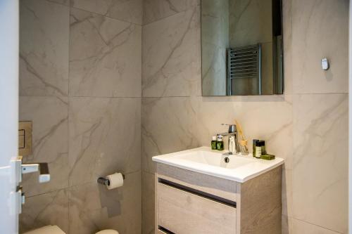 a bathroom with a sink and a mirror at Phaedrus Living: 360 Tower Luxury Flat in Nicosia