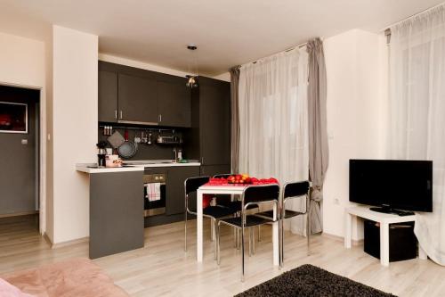 a kitchen with a table and chairs in a room at Апартамент до парк и метро in Sofia