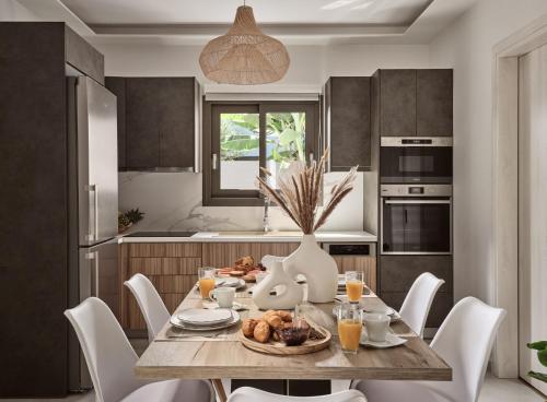 a kitchen with a table with a plate of food on it at Kapodistria Luxury Villas - Serene Escape in a Scenic, Secluded Location, by ZanteWize in Plános