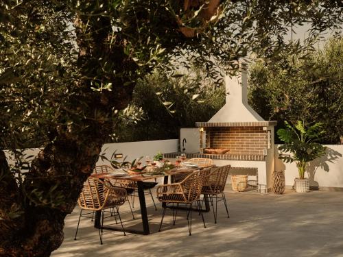 tavolo e sedie con tavolo e camino di Kapodistria Luxury Villas a Plános