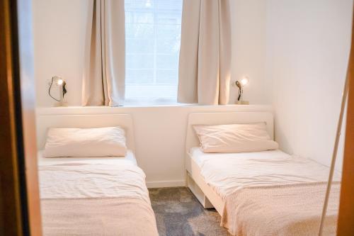 two beds in a room with a window at Ferienwohnung Im alten Feld in Schmallenberg