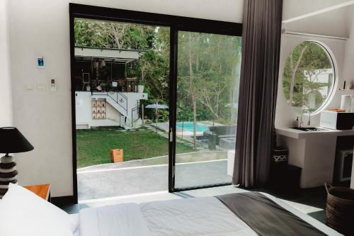 a bedroom with a large glass door leading to a backyard at The Volter Yogyakarta in Ngingas