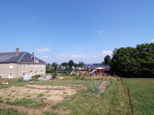 une ferme avec une maison et un champ dans l'établissement Roulotte dans les Ardennes, à Belval