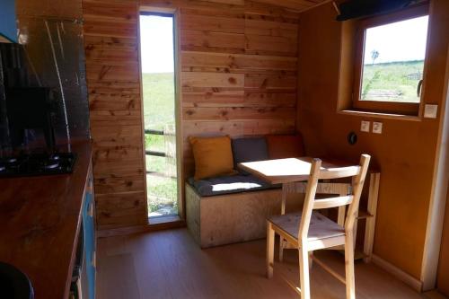 une petite salle à manger avec une table et une fenêtre dans l'établissement Roulotte dans les Ardennes, à Belval
