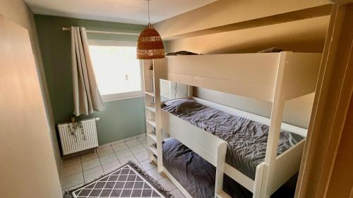 een slaapkamer met een stapelbed in een kamer met een raam bij BeCosy Appartement 6 pers 2 chambres à Leuze in Leuze-en-Hainaut