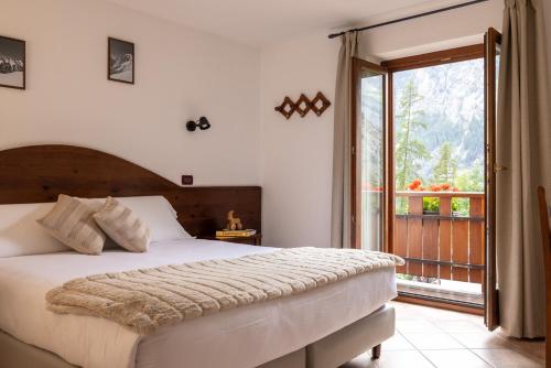 a bedroom with a large bed and a balcony at Le Rêve in Courmayeur