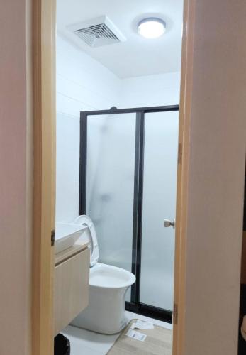 une salle de bains avec toilettes et douche en verre dans l'établissement Marinduque Bed and Breakfast, à Maniwaya