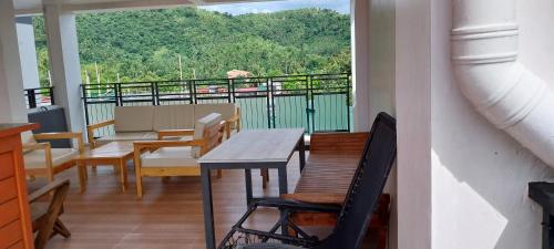 balcón con mesa, sillas y vistas en Marinduque Bed and Breakfast, en Maniwaya