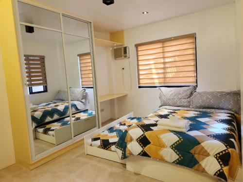 une chambre avec un lit et un grand miroir dans l'établissement Marinduque Bed and Breakfast, à Maniwaya