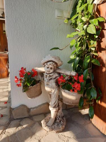a statue of a little boy next to some flowers at Casa Izvorul Rarăului in Câmpulung Moldovenesc