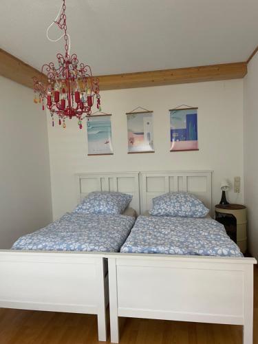 a bed in a bedroom with a chandelier at Apartment mit Ausblick in Lambrecht