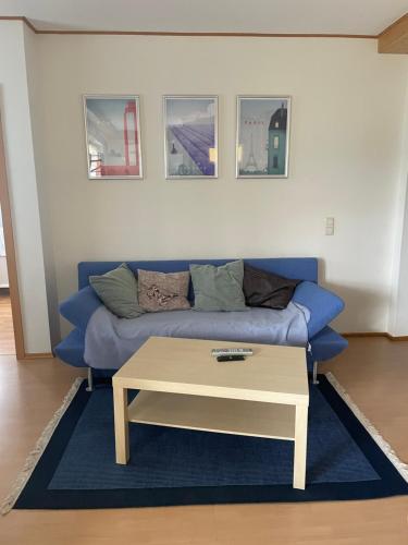 a living room with a blue couch and a coffee table at Apartment im Pfälzerwald in Lambrecht