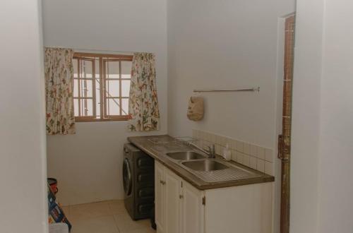 una pequeña cocina con fregadero y ventana en 373 on Bristol Home, en Port Edward