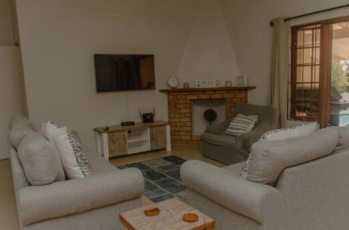 sala de estar con 2 sofás y chimenea en 373 on Bristol Home en Port Edward