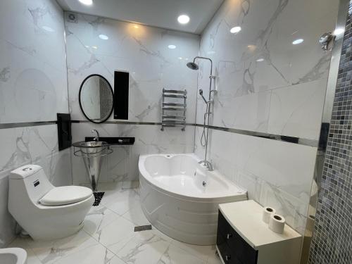 a white bathroom with a toilet and a sink at Sahil Lux in Baku
