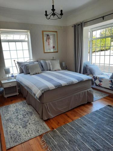 una camera con un grande letto in una stanza con finestre di Butterhouse a Trim