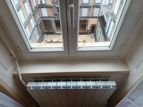 um radiador vazio debaixo de uma janela num edifício em Appartement résidence Sarciron em Le Mont-Dore
