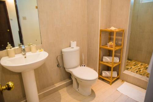 ein Badezimmer mit einem weißen WC und einem Waschbecken in der Unterkunft Island Villa in Grand-Gaube