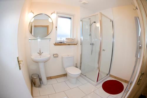 uma casa de banho com um chuveiro, um WC e um lavatório. em Lochleven Seafood Cottage em Onich