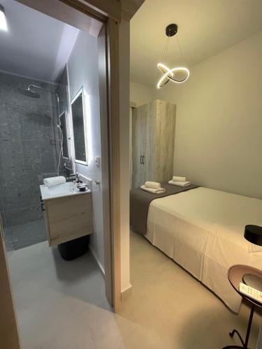 a bathroom with a bed and a shower and a sink at Villa Rodelia in Roda