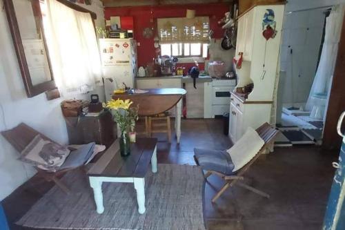een woonkamer met een tafel en een keuken bij Maitri in Neptunia