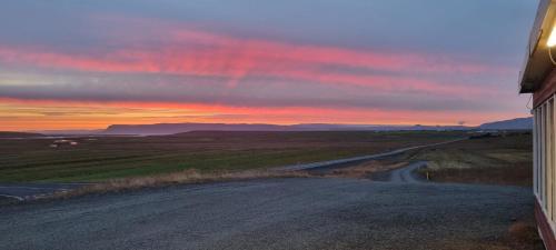 an empty road with a sunset in the distance at Gil guesthouse in Búðardalur