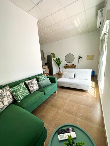 a living room with a green couch and a table at Casa Almanzora, apartamento de 1 dormitorio, wifi, parking gratuito in Zurgena