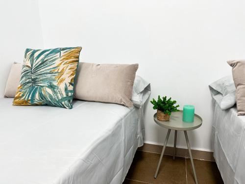 een bed met een kussen en een tafel met een plant bij Casa Almanzora in Zurgena