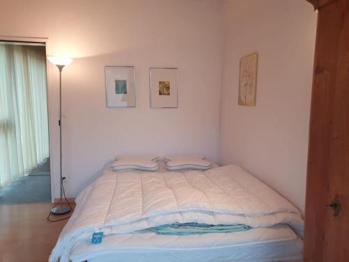 a white bedroom with a bed with two towels on it at Casa Nadja, nähe Skigebiet Flims-Lax in Ems