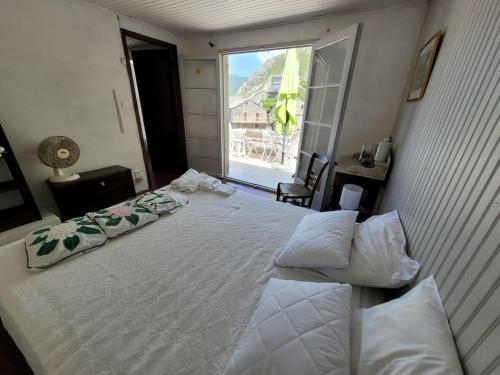 une chambre avec un grand lit blanc avec une fenêtre dans l'établissement Waterfront Authentic Corsican house, à Pino