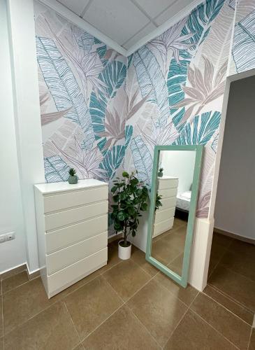 a bathroom with a mirror and a flower wall at Casa Almanzora, apartamento de 1 dormitorio, wifi, parking gratuito in Zurgena