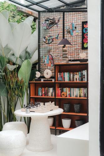 a table in front of a book shelf with books at The Volter Yogyakarta in Ngingas