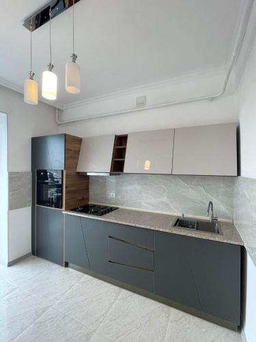 a kitchen with white cabinets and a sink at Tsius apartment in Kutaisi