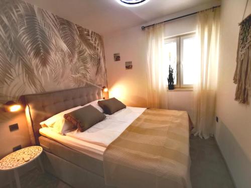 - une chambre avec un grand lit et une fenêtre dans l'établissement Apartment Beachfeeling, à Srima