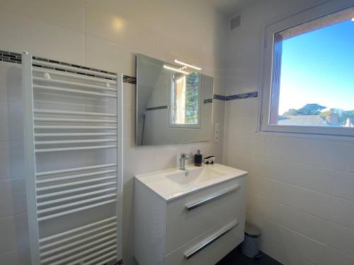 a white bathroom with a sink and a mirror at Maison avec Jardin, WIFI, proche plage et commerces, calme - Perros-Guirec - FR-1-368-374 in Perros-Guirec