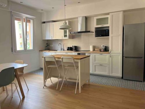 Una cocina con gabinetes blancos y una mesa y sillas. en Pelusia apartment, en Módena