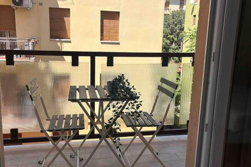 een balkon met 2 stoelen en een tafel met een plant bij Pelusia apartment in Modena