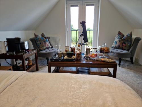 una camera con letto, tavolo e sedie di Hillvine a Hartpury