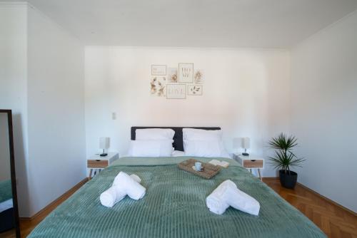 ein Schlafzimmer mit einem großen grünen Bett mit zwei Kissen in der Unterkunft BeSSa Homes Haag 6 Personen 2 Schlafzimmer, 3 Betten, Balkon in Haag in Oberbayern