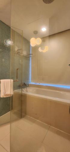 uma casa de banho com uma banheira e um chuveiro em vidro. em SUPER KING BED STUDIO walking distance to Petronas Twin Tower em Kuala Lumpur