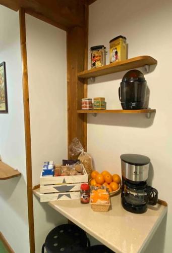 uno scaffale con una macchina per il caffè e delle arance sopra di Centro histórico Barrio Húmedo Acogedor Rústico a León