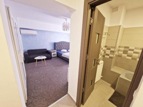 um quarto com um sofá, uma cama e uma mesa em Marcos Apartments - self check-in em Reşiţa